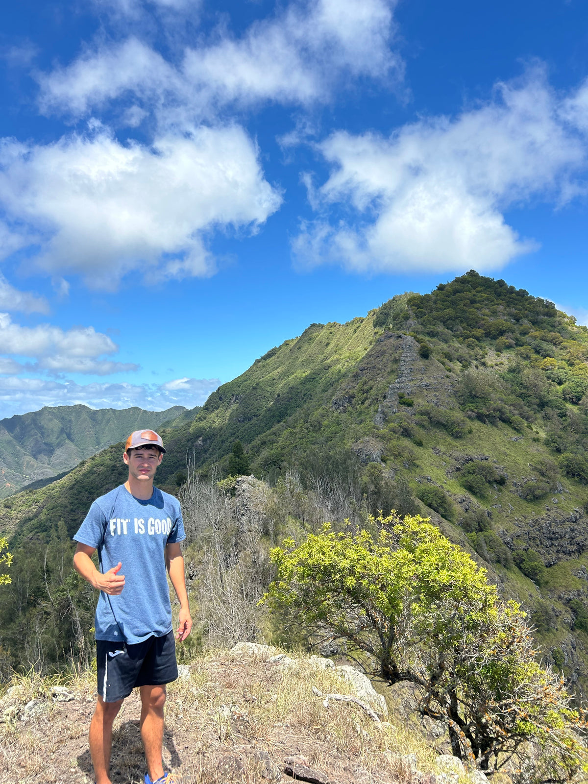 Wearing the FIT IS GOOD Tee in Heather Blue on an Oahu, Hawaii ridge hike