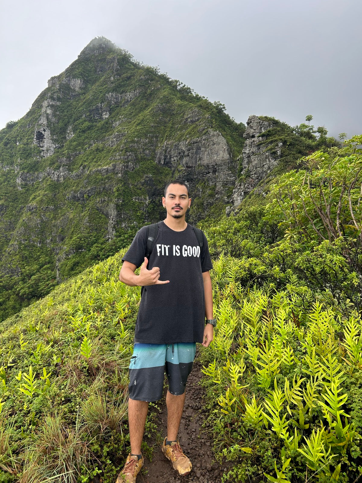 Wearing the FIT IS GOOD Tee in Charcoal on a misty Oahu, Hawaii ridge hike
